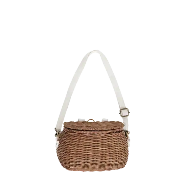 Rieten handtas met witte schouderriem voor baby spa accessoires.