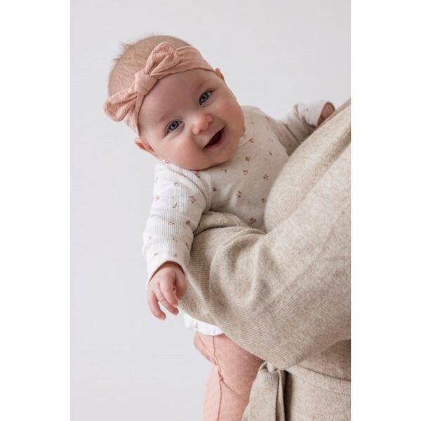 Baby met roze haarband en vrolijk gezicht, schattige babyaccessoire, Little Rosebud roze haarband.