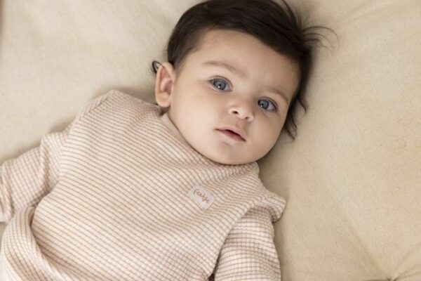 Schattige baby in wafelpyjama met stroopwafelprint, comfortabel en zacht.